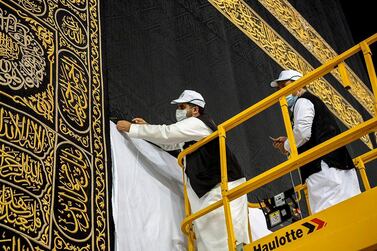 Workers wearing protective face masks work on raising the Kiswa, a silk cloth covering the Holy Kaaba, before the annual pilgrimage season, at the Grand Mosque in Mecca, Saudi Arabia July 22, 2020. Saudi Press Agency/Handout via REUTERS ATTENTION EDITORS - THIS PICTURE WAS PROVIDED BY A THIRD PARTY.