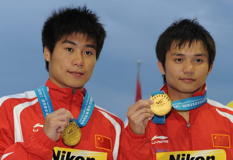 China's Qiu Bo and Huo Liang pose with their gold medals after the award ceremony for the men's 10-metre synchronised platform diving event of the FINA World Championships at the outdoor diving pool at the Oriental Sports Centre in Shanghai on July 17, 2011. AFP PHOTO / MARK RALSTON
 *** Local Caption ***  437276-01-08.jpg