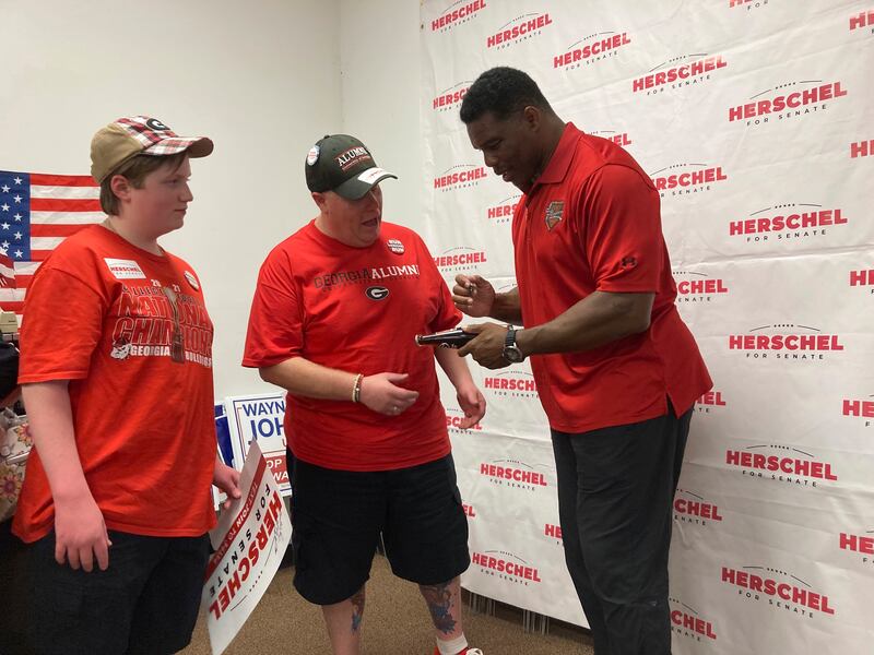 Georgia Republican Senate candidate Herschel Walker signs a soda bottle commemorating the 1980 football championship he won with the University of Georgia in Columbus. AP