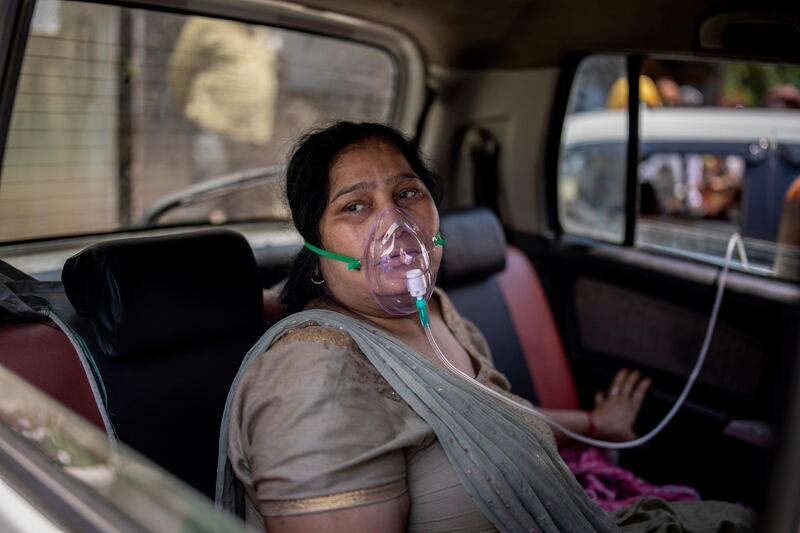 FILE - In this April 24, 2021, file photo, a COVID-19 patient sits in a car and breathes with the help of oxygen provided by a Gurdwara, a Sikh house of worship, in New Delhi, India. Despite clear signs that India was being swamped by another surge of coronavirus infections, Prime Minister Narendra Modi refused to cancel campaign rallies, a major Hindu festival and cricket matches with spectators. The crisis has badly dented Modiâ€™s carefully cultivated image as an able technocrat.  (AP Photo/Altaf Qadri, File)