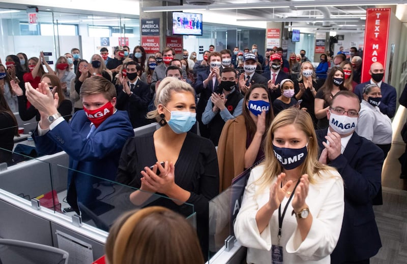 Campaign workers applaud as President Donald Trump visits his campaign headquarters in Arlington. AFP