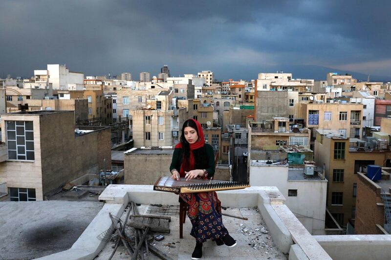 Mojgan Hosseini, 28, member of the National Orchestra of Iran, plays Qanun on the roof of her home during mandatory self-isolation due to the new coronavirus disease outbreak, in Tehran, Iran, March 26. Ebrahim Noroozi / AP