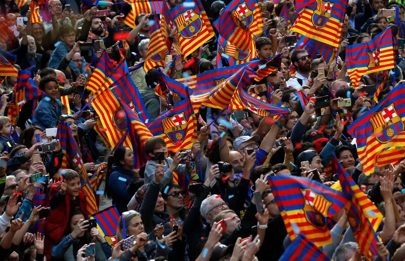 Barcelona fans take pictures, wave flags and cheer as the bus carrying the team goes past. Manu Fernandez / AP Photo