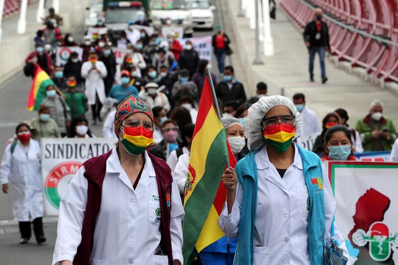 Health workers march in protest against the recently approved Sanitary Emergency law in La Paz, Bolivia. The law bans health workers from striking during Covid-19 pandemic and allows for foreign medics to be hired. EPA