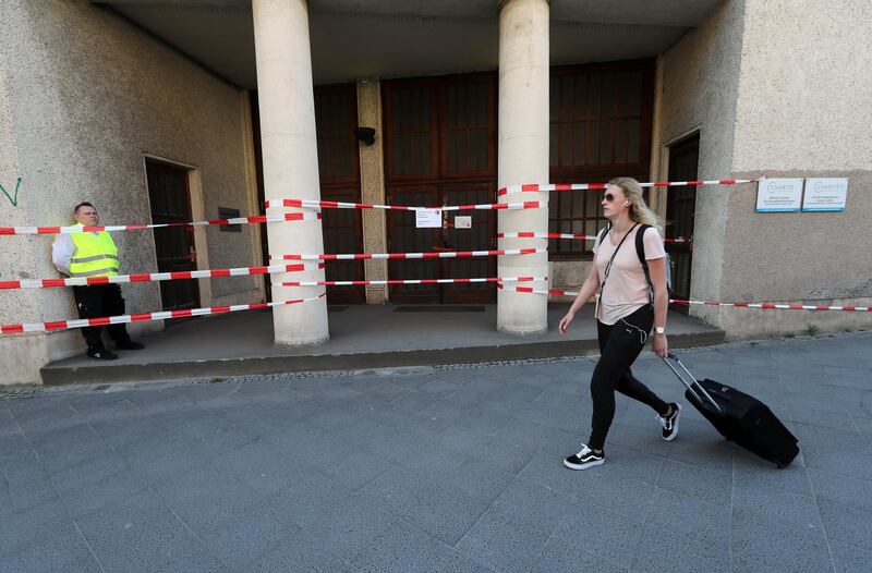 A woman with a suitcase passes a cordoned off building during the evacuation of an area of central Berlin while an unexploded bomb from the Second World War was defused on April 20, 2018. Felipe Trueba / EPA