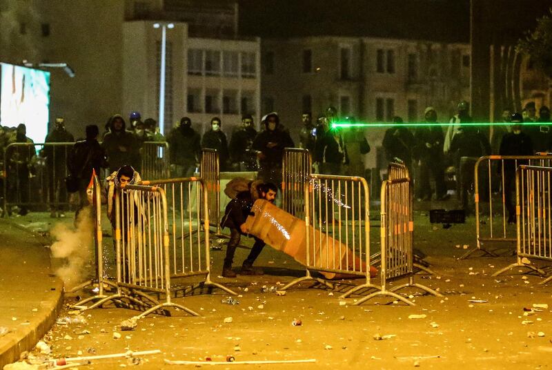 Protesters blockade the street as they throw stones at riot police during clashes in central Beirut.  EPA