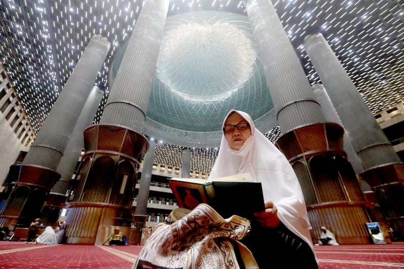 A woman reads the Quran as she waits for iftar at Istiqlal Mosque in Jakarta, Indonesia. EPA