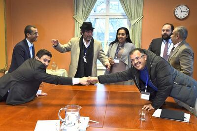 Houthi delegate Abdelqader Mourtada (L) and government delegate of Yemen Brigadier General Asker Zaeel shake hands at the negotiating table next to representatives from the office of the UN Special Envoy for Yemen and the International Red Cross Committee (ICRC) during the ongoing peace talks on Yemen held at Johannesberg Castle in Rimbo, north of Stockholm, Sweden, December 11, 2018.  / AFP / POOL / Claudio BRESCIANI
