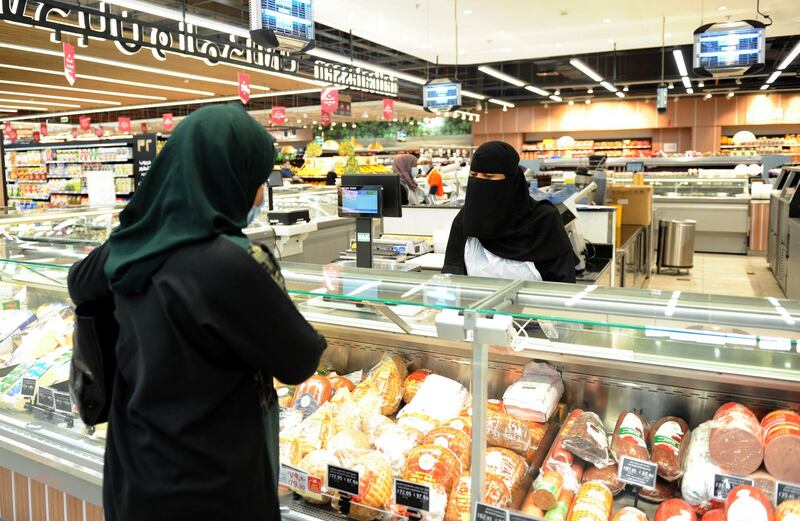 An employee serves a customer at the hypermarket. AFP