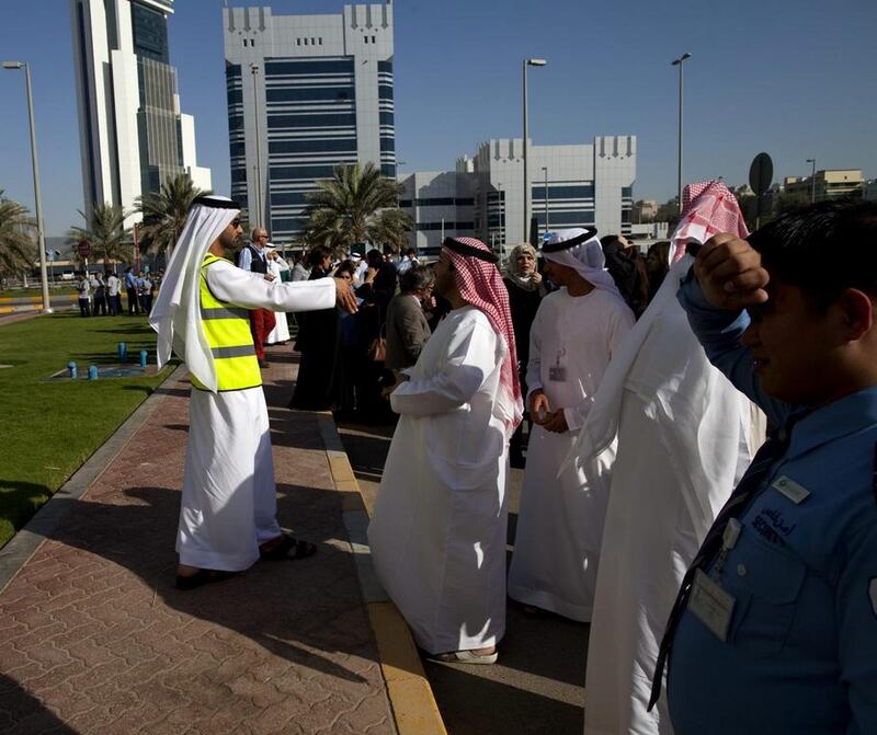 An emergency officer speaks over a loud speaker after people were evacuated from the Al Mamoura Building A in Abu Dhabi after tremors were felt from an earthquake orginating in Iran. Christopher Pike / The National 