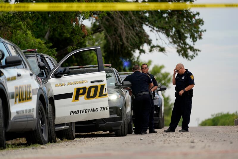 Police guard the scene where dozens of people were found dead. AP