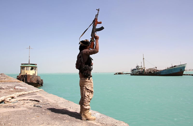 A member of the pro-government forces raises his weapon in the port of the western Yemeni coastal town of Mokha as they advance in a bid to try to drive the Shiite Huthi rebels away from the Red Sea coast on February 9, 2017.     
Forces supporting President Abedrabbo Masnour Hadi, backed by the coalition, began a major offensive on January 7 to recapture the coastline overlooking the strategic Bab al-Mandab Strait.
 / AFP PHOTO / SALEH AL-OBEIDI