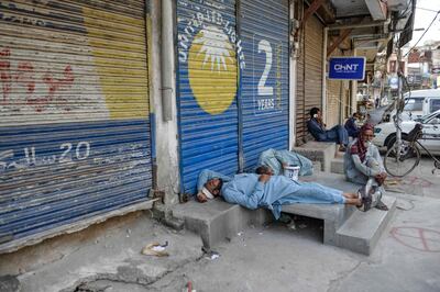 Labourers sleep near a market closed for the week-end in Rawalpindi on June 6, 2020.
    
      / AFP / Farooq NAEEM
