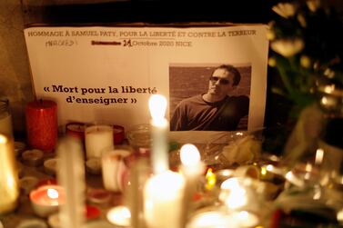 Candles are lit at a makeshift memorial as people gather to pay homage to Samuel Paty, the French teacher who was beheaded on the streets of Paris. Reuters