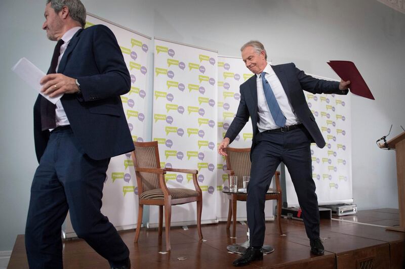 Former prime minister Tony Blair leaves the stage with host Gavin Esler after making a speech about Brexit in London Friday, Dec. 14, 2018. Blair has pressed calls for a second referendum on Brexit. (Stefan Rousseau/PA via AP)