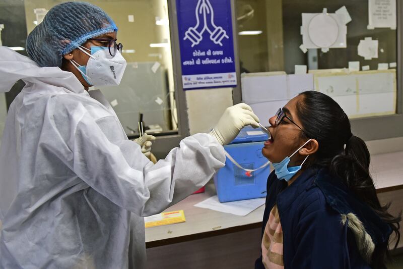 A health worker takes a swab sample from a girl at a hospital in Ahmedabad on December 27, 2022. AFP