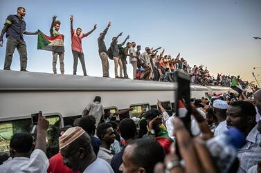 Sudanese protesters from the city of Atbara flash the V-sign for victory and wave national flags atop a train as it arrives at the Bahari station in Khartoum on April 23, 2019. AFP