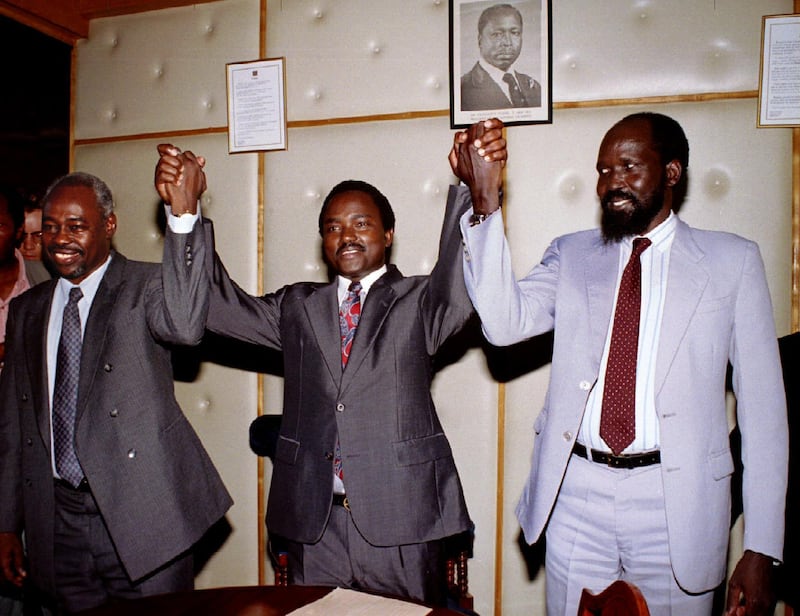 Sudanese peace talks delegation leaders Mohamed Amin Kharifa (L) from Khartoum government, Kenya Foreign Affairs Minister Karonzo Musyoka (C) and Cdr. Salva Kiir Mayardit (R) from SPLA raise their hands together after signing of peace agreement between the Khartoum government and SPLA rebels of southern Sudan in Nairobi March 23. The agreement will allow relief aid to move freely by road, sea and air to the southern area hit by 11 years of civil war