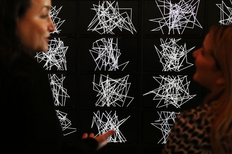 Two women talk in front of Saudi-born artist Daniah al-Saleh's 2019 audio-visual work titled "Sawtam" at Art Dubai in Dubai. AP Photo