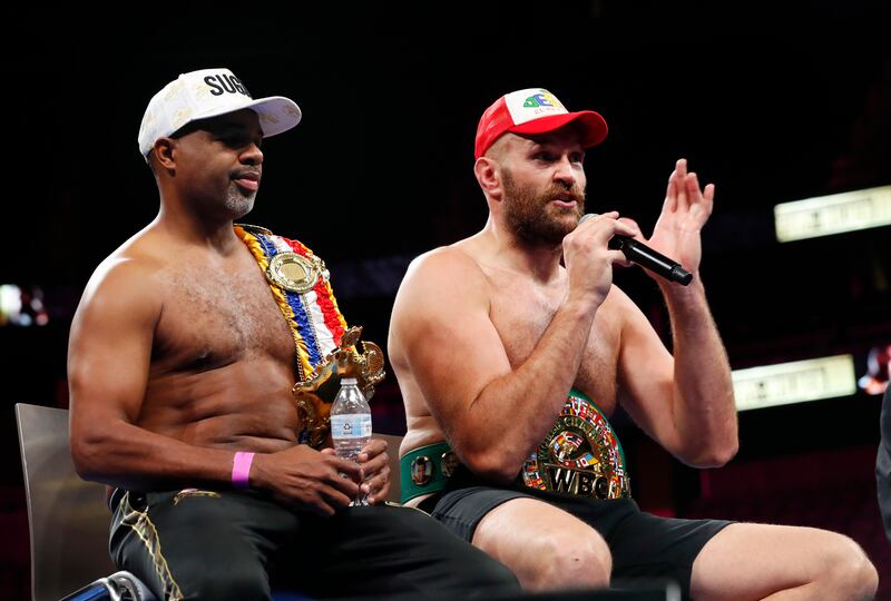 Tyson Fury and trainer SugarHill Steward with the belts during a press conference. Reuters