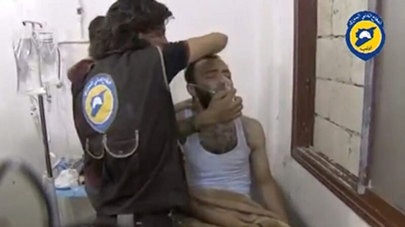 A video said to be taken on August 1, 2016, shows two men standing over another man on a bed, forcing him to sit up as he breathes through a mask in the town of Saraqeb, Idlib province. Social Media/Handout via Reuters 
