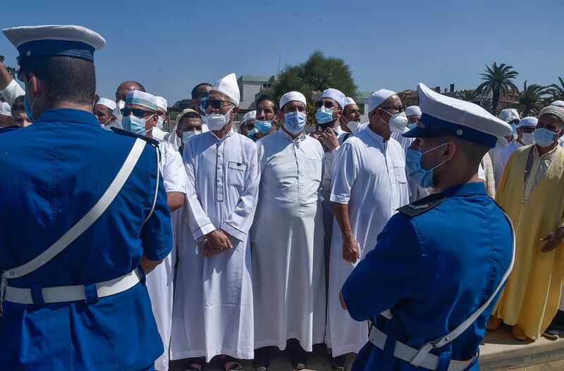 Algerian security forces stand guard as people wait for the arrival of the funerary motorcade of former president Abdelaziz Bouteflika to the El Alia cemetery in the capital Algiers. AFP