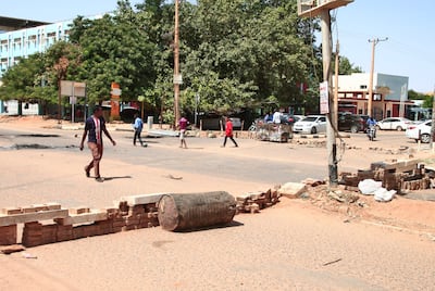 Sudanese protesters use bricks to barricade a street in Khartoum during demonstrations against the military takeover. AFP