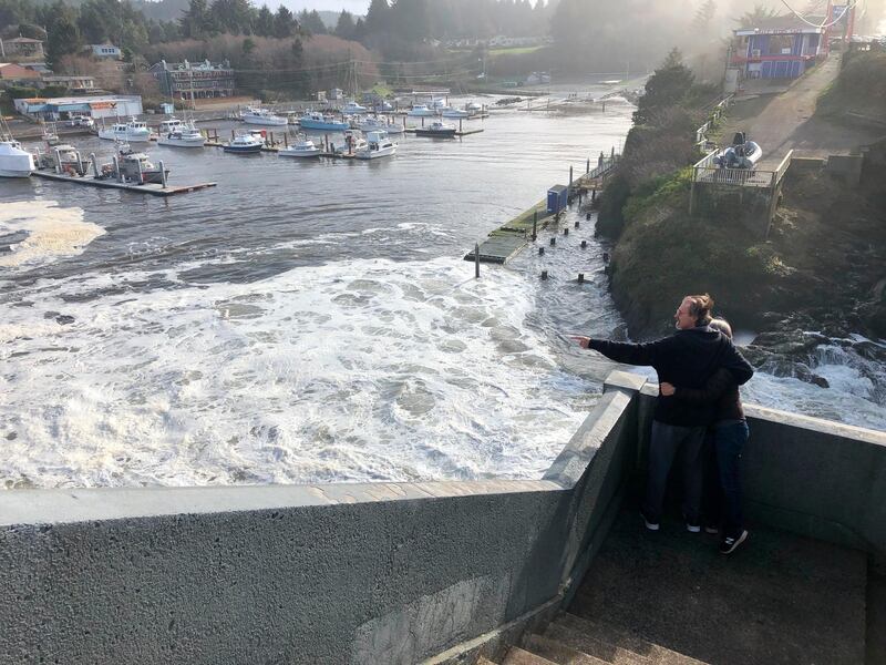 Residents watch as an extreme high tide rolls in and floods parts of the harbor in Depoe Bay, Oregon during an extreme high tide that coincided with a big winter storm.  AP Photo/Gillian Flaccus