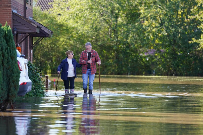 Residents walk through flood water in Retford in Nottinghamshire. PA