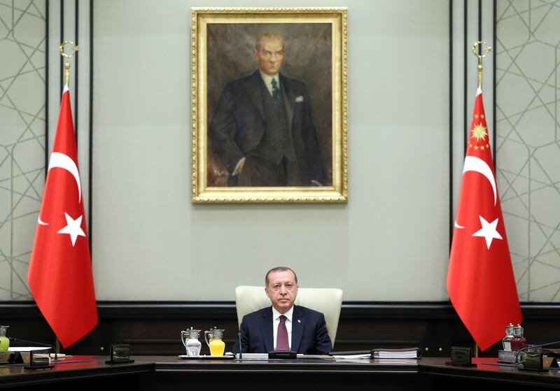 Backdropped by a painting depicting Turkey's founder Mustafa Kemal Ataturk, Turkey's President Recep Tayyip Erdogan chairs the National Security Council meeting in Ankara, Turkey, Monday, July 17, 2017. Erdogan says the country's top security advisory body will discuss on Monday whether to further extend a state of emergency that was declared after last year's failed coup. Erdogan also said he would approve "without any hesitation" any legislation that would be passed in parliament to reinstate the death penalty. (Presidency Press Service Pool Photo via AP)