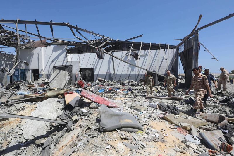 Migrants check the rubble of a destroyed detention centre in Tripoli's, Libya.  EPA