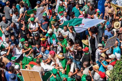 Algerian demonstrators chant slogans and march with national flags as they gather in the streets of the capital Algiers against the ruling class amid an ongoing political crisis in the country, on the 26th consecutive Friday of protests on August 16, 2019.  / AFP / RYAD KRAMDI                        
