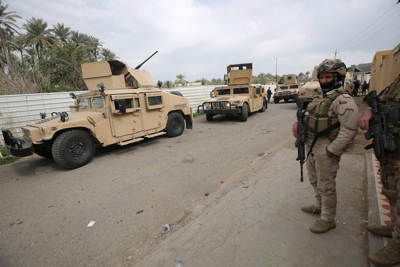 Iraqi forces search the area in Tarmiyah, 35 kilometres (20 miles) north of Baghdad on February 20, 2021, following clashes with Islamic State group fighters. Iraqi security forces clashed with the Islamic State group north of Baghdad, leaving at least five jihadists and two security personnel dead. A joint force of army troops and state-sponsored tribal fighters raided an IS hideout in the leafy plains of Tarmiyah, according to a statement from the military. / AFP / AHMAD AL-RUBAYE
