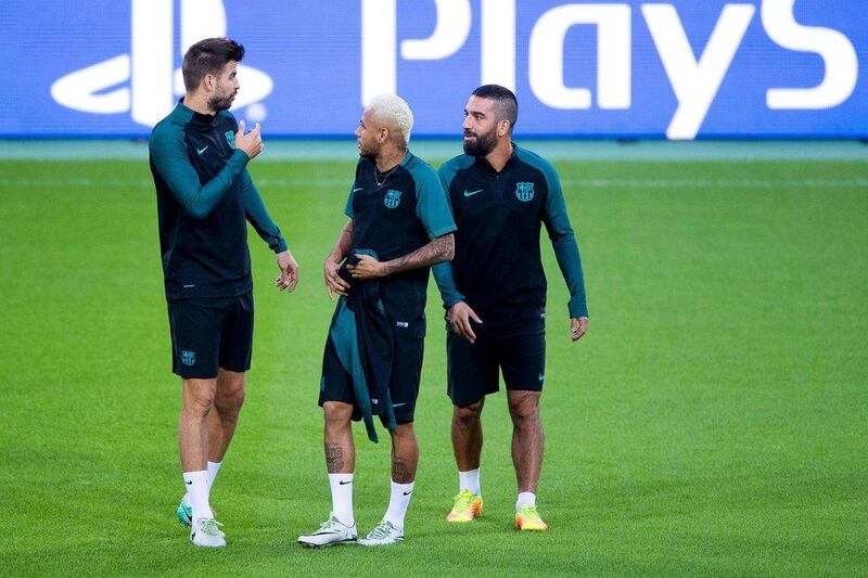 Barcelona players, left to right, Gerard Pique, Neymar, and Arda Turan attend their team’s training session. Marius Becker / EPA