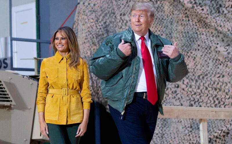 TOPSHOT - US President Donald Trump and First Lady Melania Trump arrive to speak to members of the US military during an unannounced trip to Al Asad Air Base in Iraq on December 26, 2018. President Donald Trump arrived in Iraq on his first visit to US troops deployed in a war zone since his election two years ago / AFP / SAUL LOEB
