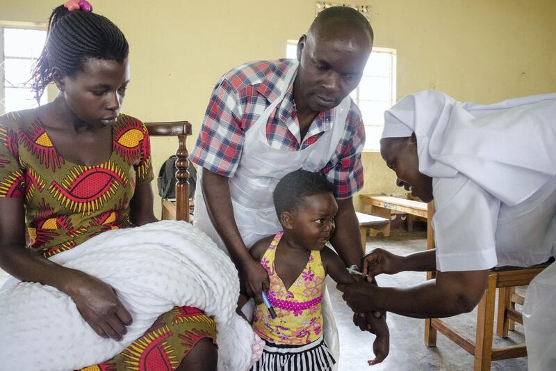 A child reacts as he receives an injection during the nationwide vaccination campaign against measles, rubella and polio targeting all children under 15 years old in Nkozi town, about 84 km from the capital Kampala, on October 19, 2019. - Uganda's Ministry of health with WHO and UNICEF aim to immunize more than 18 million children in Uganda which is about 43 percent of the population during their 5-day vaccination campaign. (Photo by Badru KATUMBA / AFP)