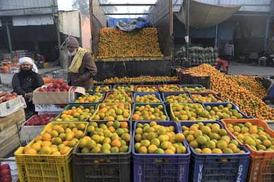 Vendors wait for customers at a wholesale fruit and vegetable market in Ghaziabad on December 8, 2020. - Indian farmers who have been blockading New Delhi on December 8 launched a one-day, nationwide general strike to push their demands for the government to repeal reform laws opening up trade in agricultural produce. (Photo by Prakash SINGH / AFP)