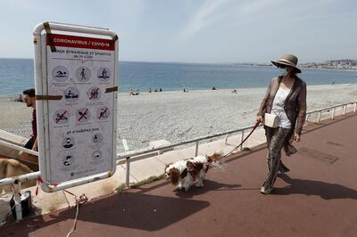 epa08437386 A woman reads a poster displaying new hygiene and distancing rules on the beach of in Nice, southern France, 22 May 2020. Several countries around the globe have started to ease their COVID-19 lockdown restrictions in an effort to restart their economies and help people get back to their daily routines after the outbreak of the SARS-CoV-2 coronavirus pandemic.  EPA/SEBASTIEN NOGIER