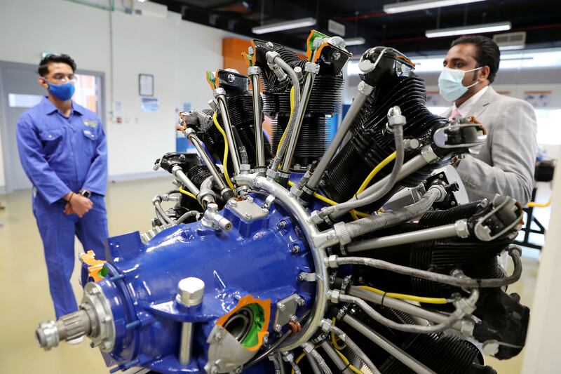 Sarath Raj, Programme Leader, Aerospace Engineering, right, explaining to the Aerospace Science students about the radial engine at Amity University's Aerospace Lab in Academic City in Dubai. Pawan Singh / The National