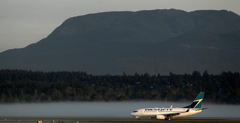 A WestJet Airlines Boeing 737-700 taxis past low-lying fog at Vancouver International Airport. The airline is based in Canada. Darryl Dyck / AP
