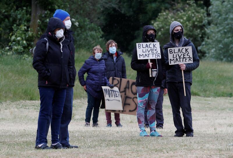 Demonstrators are seen in the rain wearing protective face masks during a Black Lives Matter protest in Verulamium Park, St Albans, Britain, following the death of George Floyd in police custody in Minneapolis, on June 6, 2020. Reuters