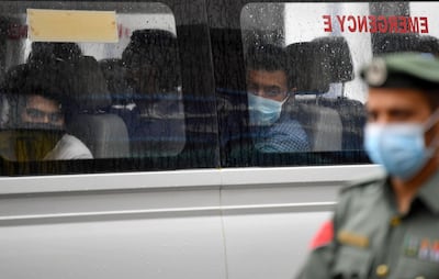 Foreign workers who have tested positive to the novel coronavirus at a testing centre in the Naif area of the Gulf Emirate of Dubai, wait in a bus before being transported to  a specialised centre for isolation and treatment, on April 15, 2020.  / AFP / KARIM SAHIB
