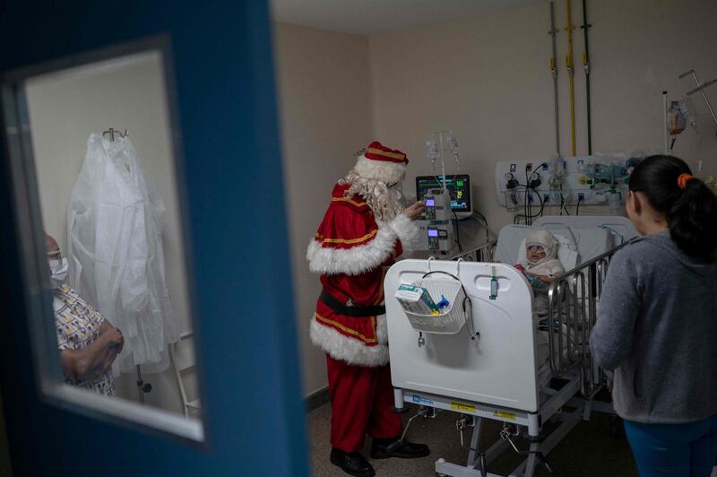 Santa Claus greets a mother and her child during a visit to the Souza Aguiar Municipal Hospital in Rio de Janeiro, Brazil. AFP