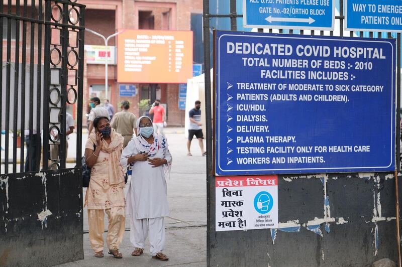 People exit a gate at the Lok Nayak Hospital in New Delhi, India. Bloomberg