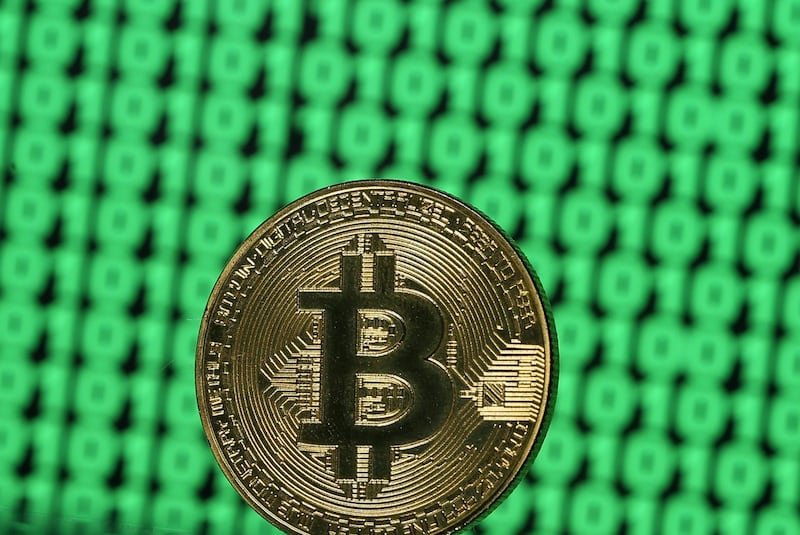 A token of the virtual currency Bitcoin is seen placed on a monitor that displays binary digits in this illustration picture, December 8, 2017. Picture taken December 8. REUTERS/Dado Ruvic/Illustration