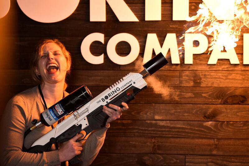 An attendee operates a Boring Company flamethrower at the company's photo booth. Reuters