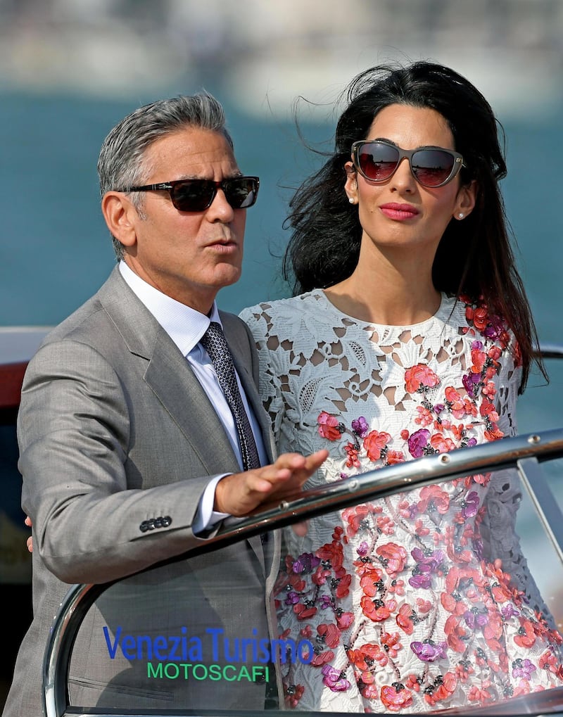 epa04421758 Newlywed couple, US actor George Clooney (L) and his wife Amal Alamuddin (R) stand on a taxi boat, in Venice, Italy, 28 September 2014. Clooney and Alamuddin got married the day before at the Aman Resort hotel.  EPA/ALESSANDRO DI MEO