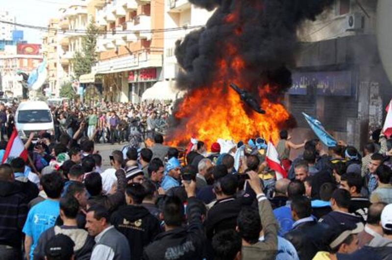 Lebanese Sunni Muslim supporters of Lebanon's caretaker Prime Minister Saad al-Hariri protest around a burning satellite truck used by Al Jazeera tv channel during what they called "a day of anger" in Tripoli, northern Lebanon, against the expected nomination of Hezbollah-backed Najib Mikati to form the next government, January 25, 2011. Supporters of Hariri set fire to a vehicle used by the Arab television channel Al Jazeera during protests in the northern city of Tripoli on Tuesday, witnesses said. 
REUTERS/ Mohamed Azakir  (LEBANON - Tags: POLITICS CIVIL UNREST IMAGES OF THE DAY)