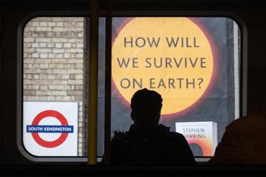 A sign advertising a book titled "How Will We Survive On Earth?" is seen on an underground station platform  in London, England. Getty