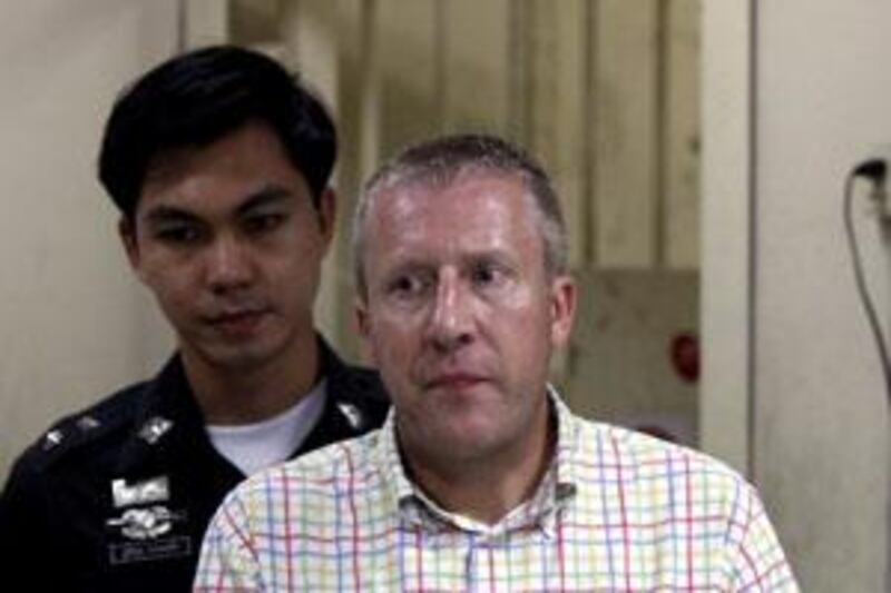 Michael Bryan Smith, in handcuffs in Bangkok, faces extradition to the UAE.